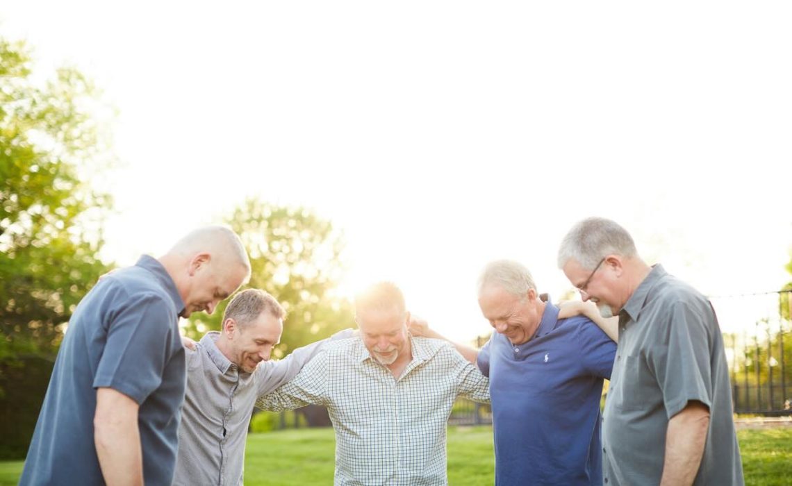 Men outdoors praying